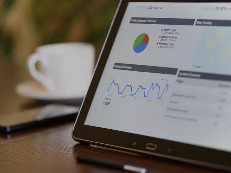 Tablet displaying a data screen next to a cup of coffee