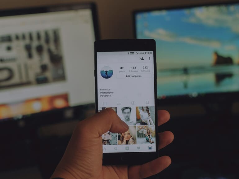 Main d'homme tenant un smartphone avec Instagram sur l'écran