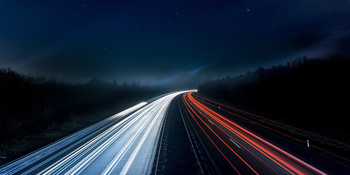 Autoute vue de nuit avec les feux des voitures laissant une traînée lumineuse.