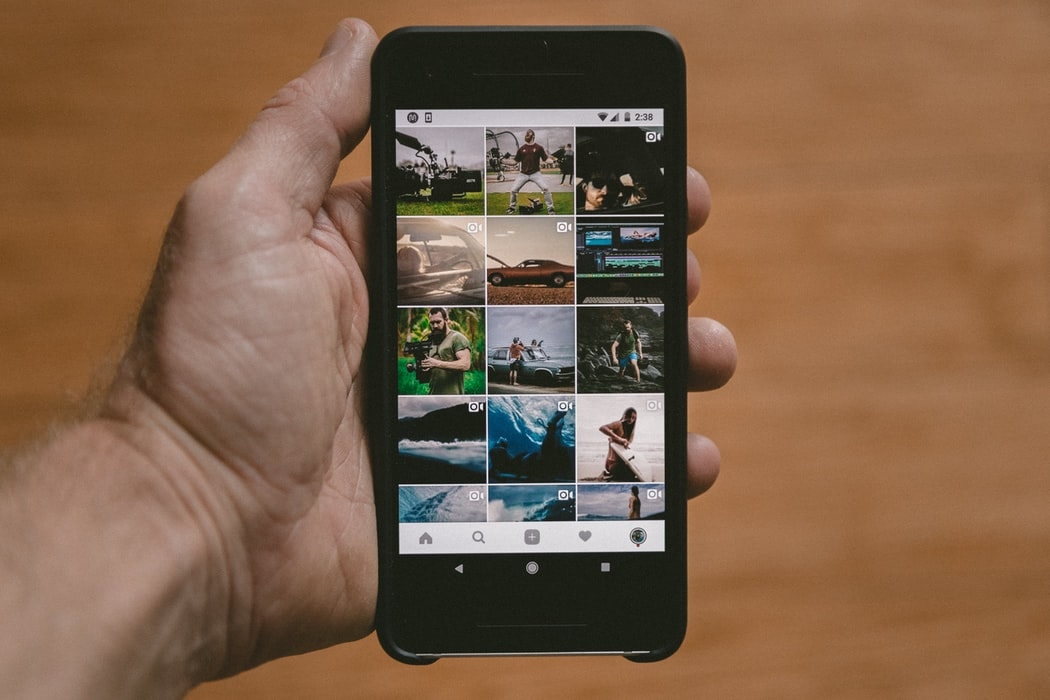 photo-1518991043280-1da61d9f3ac5 Main d'homme tenant un smartphone avec Instagram sur l'écran