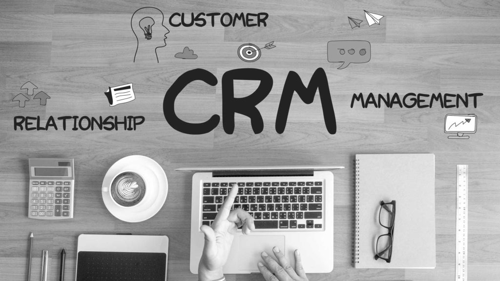 L'expression CRM écrit sur un un bureau où une personne est en train de travailler