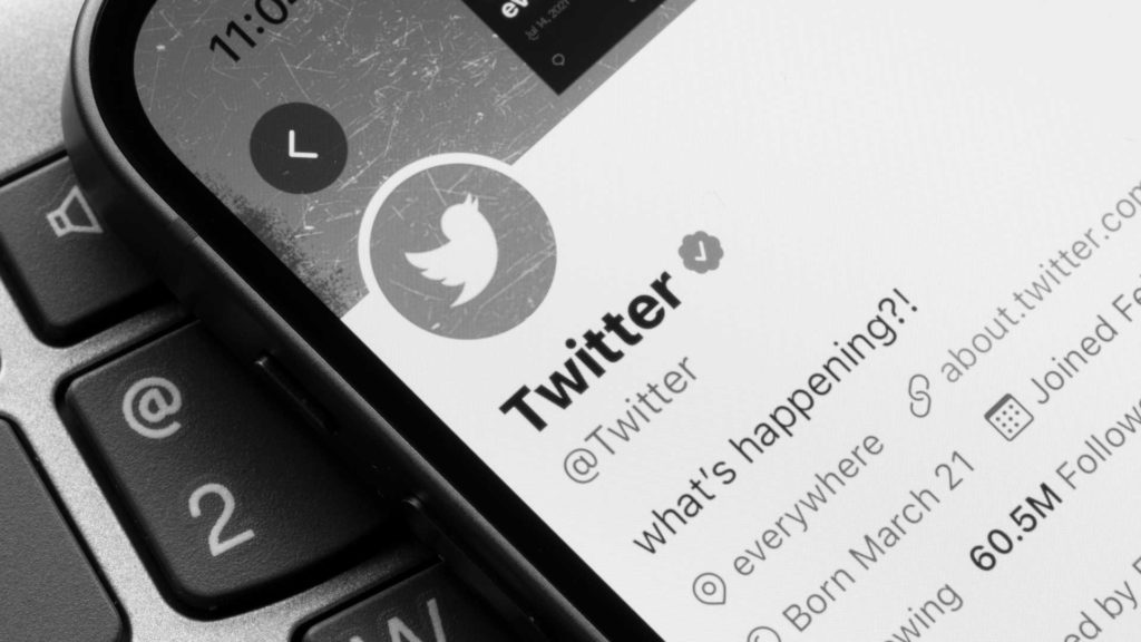 Un écran de téléphone sur lequel on voit l'application Twitter et le logo de la marque.